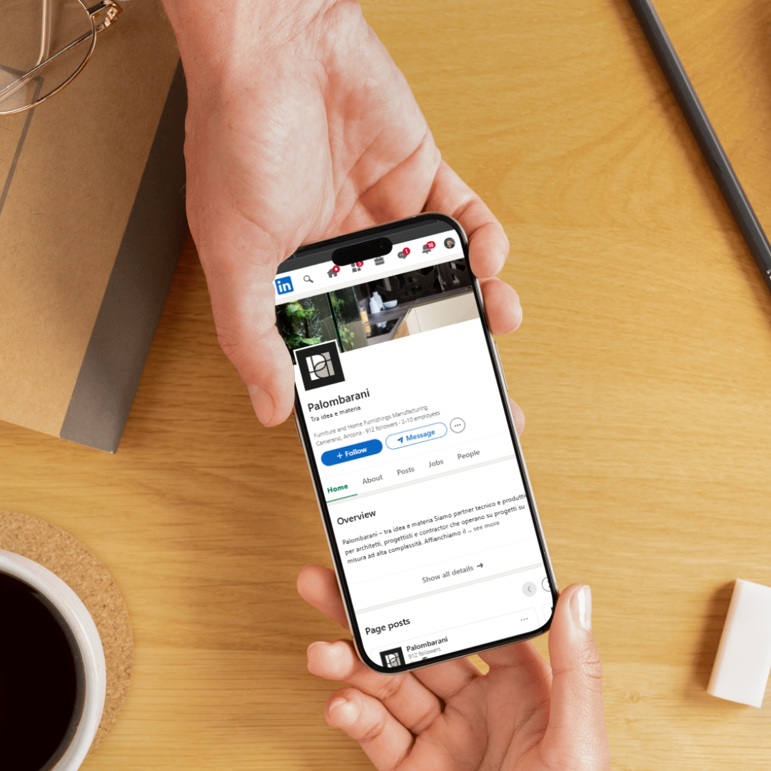 Mani che tengono uno smartphone con la pagina LinkedIn di Palombarani aperta.